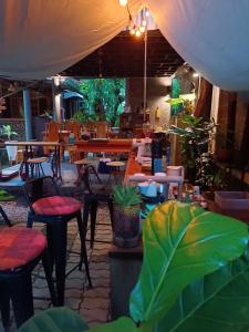un restaurant avec des tables, des chaises et des plantes dans l'établissement Cabinthai, à Mae Chaem