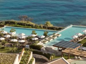uma vista aérea de uma piscina com guarda-sóis e do oceano em Lesante Cape Resort & Villas - The Leading Hotels of the World em Akrotiri
