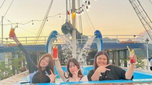 Trzy dziewczyny są na zjeżdżalni wodnej na łodzi. w obiekcie Lan Ha Lotus Cruise w Ha Long