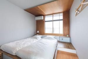 ein Schlafzimmer mit einem weißen Bett und einem Fenster in der Unterkunft Okazaki Micro Hotel ANGLE in Okazaki