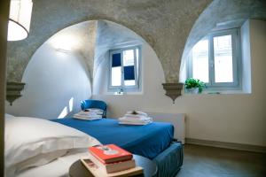 a bedroom with a blue bed and two windows at Casa S a f e r in Florence