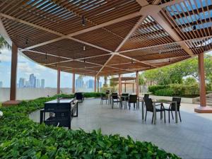 een patio met tafels en stoelen onder een houten parasol bij Almas Suite Modern Comfy Studio House in Gelang Patah