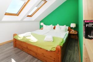 a bedroom with a bed with a green wall at Ferienwohnung Naturparadies Gnitz in Lütow