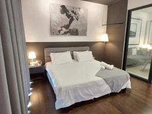 een slaapkamer met een groot wit bed en een spiegel bij Almas Suite Modern Comfy Studio House in Gelang Patah