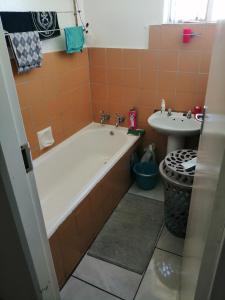 a bathroom with a tub and a sink at Kingswood Flats in Pretoria