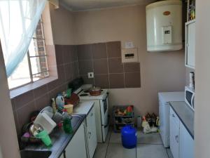 a small kitchen with a sink and a window at Kingswood Flats in Pretoria