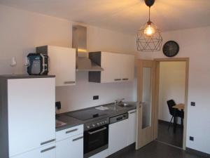 a kitchen with white cabinets and a sink at PARSBERGER FERIENWOHNUNG in Parsberg