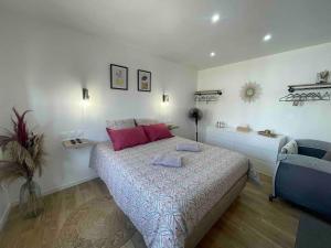 Un dormitorio con una cama con almohadas rosas. en La Casa di Maria - Gîte 2 à 4 personnes, en Lespesses