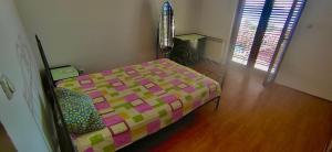 a bedroom with a bed with a colorful comforter at Natalia Rooms Old Town in Herceg-Novi
