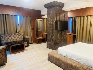 a hotel room with a bed and a couch and a television at Hotel Rajmahal in Guwahati