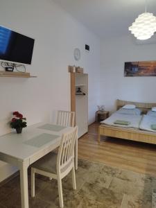 ein Wohnzimmer mit einem Tisch und einem Bett in der Unterkunft Holling apartman in Fertőboz