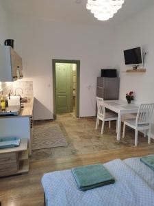 a kitchen and dining room with a table and chairs at Holling apartman in Fertőboz
