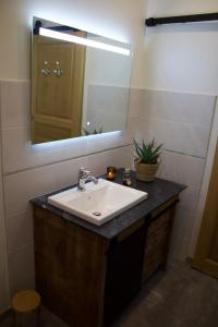La salle de bains est pourvue d'un lavabo et d'un miroir. dans l'établissement Maison de charme au cœur de la baie de Somme, à Saint-Valery-sur-Somme
