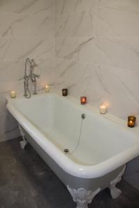 d'une baignoire blanche avec bougies. dans l'établissement Maison de charme au cœur de la baie de Somme, à Saint-Valery-sur-Somme
