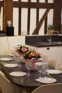 - une table avec des verres et un bouquet de fleurs dans l'établissement Maison de charme au cœur de la baie de Somme, à Saint-Valery-sur-Somme