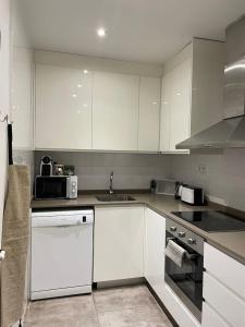 een keuken met witte kasten en een wastafel bij Nice Apartment 2 Bedrooms Well Connected in Cornellà de Llobregat