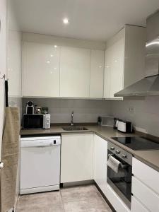 kuchnia z białymi szafkami i zlewem w obiekcie Nice Apartment 2 Bedrooms Well Connected w mieście Cornellà de Llobregat