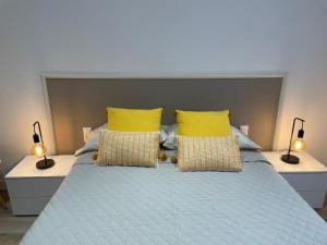 Un dormitorio con una cama azul con almohadas amarillas en Nice Apartment 2 Bedrooms Well Connected, en Cornellà de Llobregat