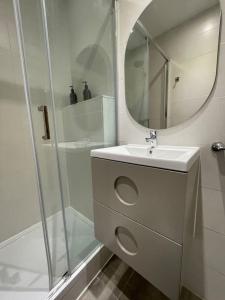 biała łazienka z umywalką i lustrem w obiekcie Nice Apartment 2 Bedrooms Well Connected w mieście Cornellà de Llobregat