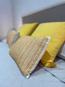 uma cama com almofadas amarelas em cima em Nice Apartment 2 Bedrooms Well Connected em Cornellà de Llobregat