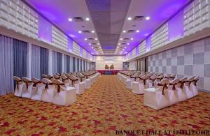 una fila de sillas en una habitación con iluminación púrpura en Hotel Rajmahal, en Guwahati