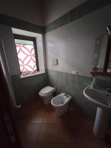 ein Bad mit einem WC, einem Waschbecken und einem Fenster in der Unterkunft Rod Ranch Livestock- Stanza matrimoniale in Campagnano di Roma