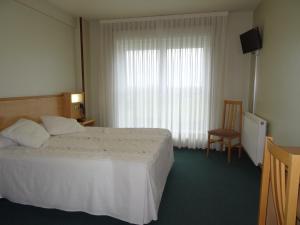 1 dormitorio con 1 cama, 1 silla y 1 ventana en Hotel Akelarre en Santiago de Compostela