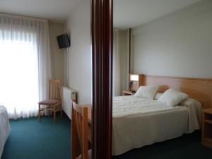 a hotel room with a bed and a mirror at Hotel Akelarre in Santiago de Compostela