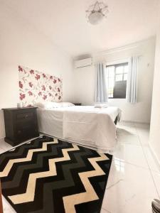 a bedroom with a bed and a black and white rug at Luxury Duplex Casa in Natal