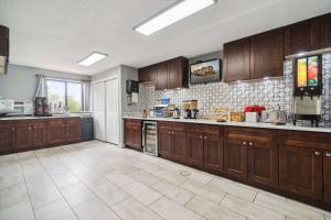 a large kitchen with wooden cabinets and a large appliance at Super 8 by Wyndham Kenosha/Pleasant Prairie in Pleasant Prairie