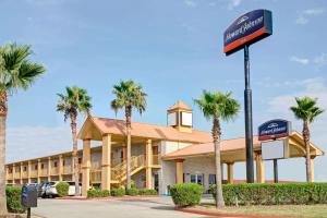 a front view of a hotel with palm trees at Howard Johnson by Wyndham Galveston in Galveston