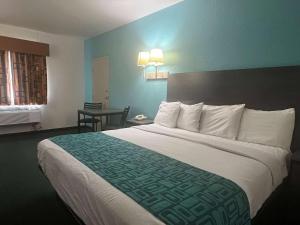 a hotel room with a large bed and a table at Howard Johnson by Wyndham Galveston in Galveston