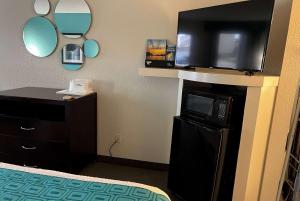 a hotel room with a flat screen tv and a bed at Howard Johnson by Wyndham Houston Heights Downtown in Houston