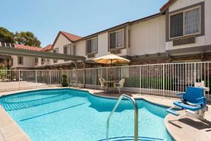 a swimming pool in front of a house at Super 8 by Wyndham Santa Clarita/Valencia in Santa Clarita