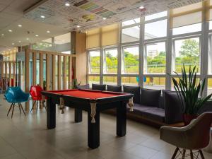 a pool table in a room with couches and chairs at ibis Novo Hamburgo in Novo Hamburgo