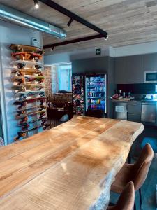a large wooden table in a room with a wine cellar at Zarautz Surf House in Zarautz