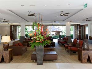 a lobby of a hotel with couches and chairs at Pullman Palm Cove Sea Temple Resort & Spa in Palm Cove