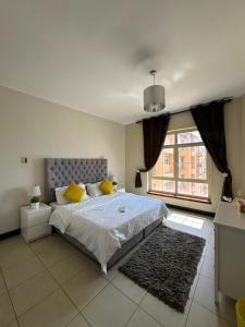 um quarto com uma cama grande e uma janela grande em شقق فخامة المارينا Grandeur Marina Apartments em King Abdullah Economic City