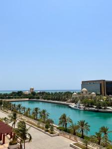 Vista arial a um rio com palmeiras e edifícios em شقق فخامة المارينا Grandeur Marina Apartments em King Abdullah Economic City