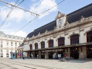 un grand bâtiment avec une tour d'horloge en haut dans l'établissement hotelF1 Bordeaux Sud Villenave d'Ornon, à Villenave-dʼOrnon