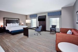 コロンビアにあるハンプトン イン ＆ スイーツ コロンビア サウスイースト フォート ジャクソンのベッドとデスクが備わるホテルルームです。