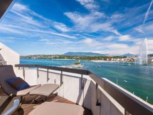 balcone con sedie e vista sull'acqua di Fairmont Grand Hotel Geneva a Ginevra