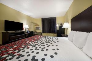 a hotel room with a bed and a flat screen tv at Econo Lodge Spotsylvania Town Center in Fredericksburg