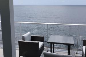 d'un balcon avec une table et des chaises sur un bateau. dans l'établissement Apt 'A Gaioa' in 'The Cliff Coast Accomodation', à Paul do Mar