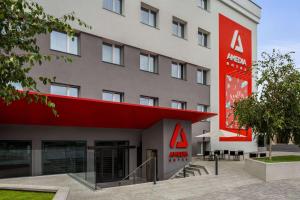 un hotel con un cartello rosso sul lato di un edificio di Amedia Milan, Trademark Collection by Wyndham a Milano
