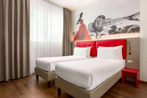 two beds in a hotel room with a red headboard at Amedia Hotel Milan, Trademark Collection by Wyndham in Milan +51 photos