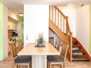 - une cuisine et une salle à manger avec une table et des escaliers dans l'établissement Feriendorf Papillon Wohnung 05-7, à Boltenhagen