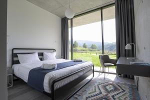 a bedroom with a bed and a large window at Concept Hotel by COAF in Debed