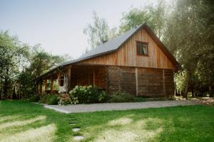 una cabaña de madera con un patio de césped delante de ella en Siedliska Samo Dobro, en Zamość