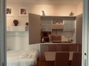 a kitchen with white cabinets and a table in a room at Futura Exclusive Suite 4 in Bari